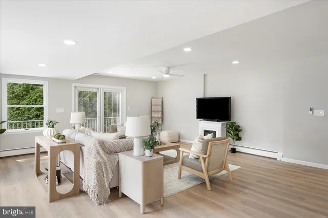 a living room with furniture a flat screen tv and a large window