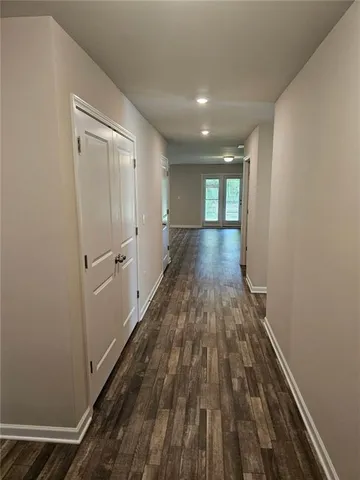 a view of a hallway with wooden floor and staircase