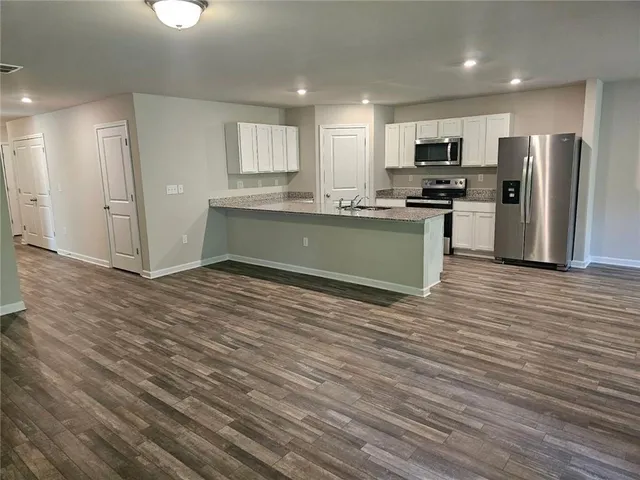 a kitchen with granite countertop a refrigerator and a sink