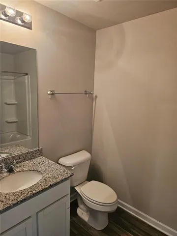 a bathroom with a granite countertop toilet and a sink