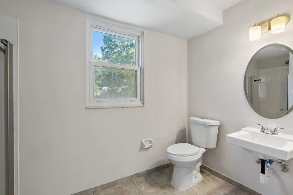 a bathroom with a toilet a sink and mirror