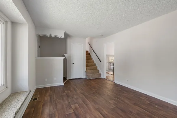 a view of a hallway with wooden floor and stairs