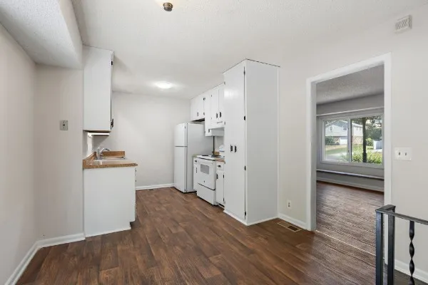 a kitchen with a refrigerator and a stove top oven