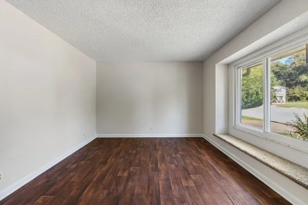a view of a room with wooden floor and large window