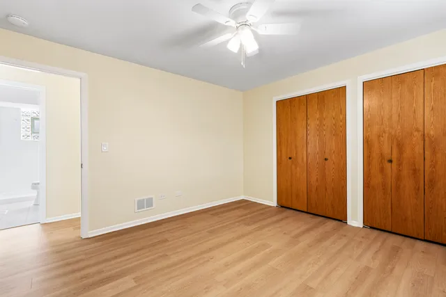 an empty room with wooden floor and closet area