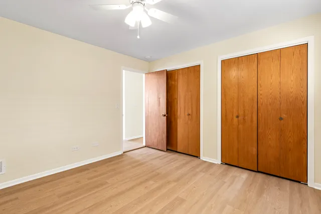 an empty room with wooden floor and closet area