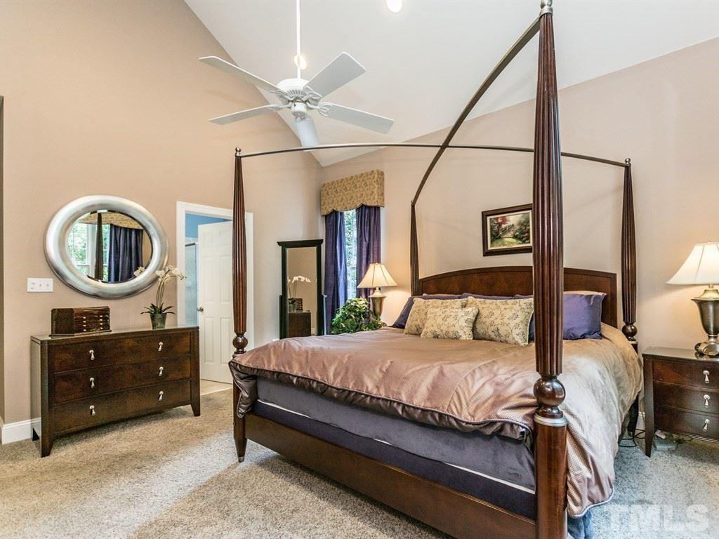 6304 Pleasant Creek Court Raleigh, NC 27613 - Photo 14 of 25 a bedroom with a bed a mirror on dresser and a chandelier