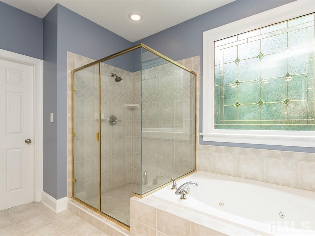 6304 Pleasant Creek Court Raleigh, NC 27613 - Photo 16 of 25 a bathroom with a bathtub and a shower