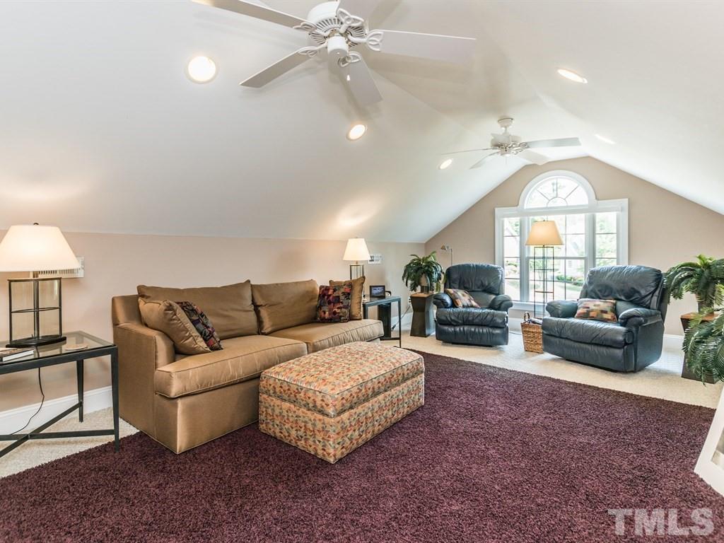 6304 Pleasant Creek Court Raleigh, NC 27613 - Photo 21 of 25 a living room with furniture a fireplace and a chandelier
