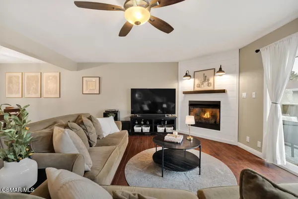 a living room with furniture a flat screen tv and a fireplace
