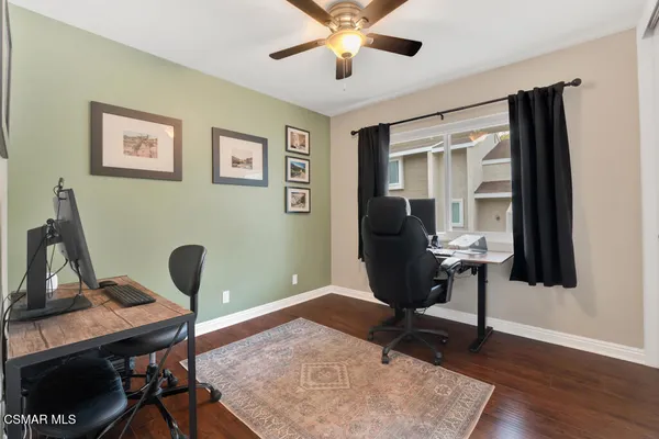 a view of a workspace with furniture and a window