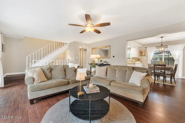 a living room with furniture a ceiling fan and a rug