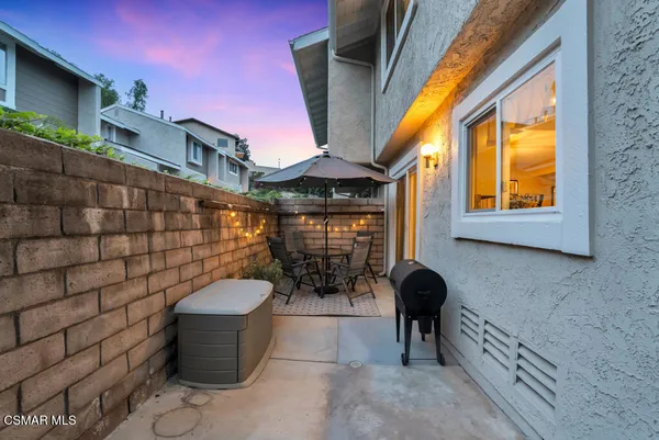 a view of a patio with a table and chairs and potted plants