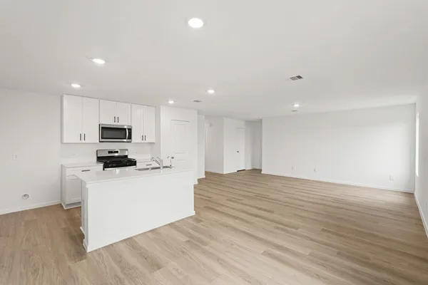 a view of kitchen with wooden floor and electronic appliances
