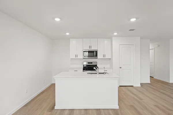 a kitchen with stainless steel appliances a sink a stove a refrigerator and cabinets
