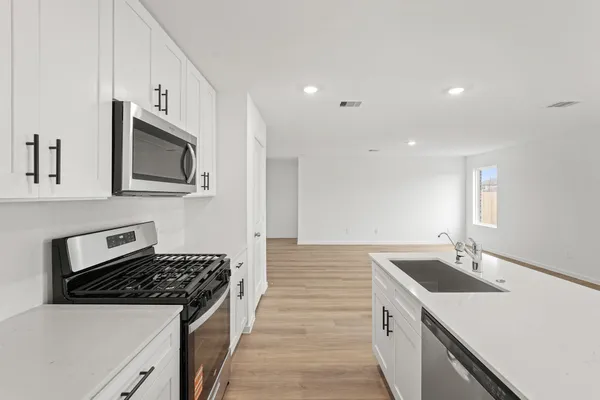 a kitchen with a sink stove top oven and cabinets