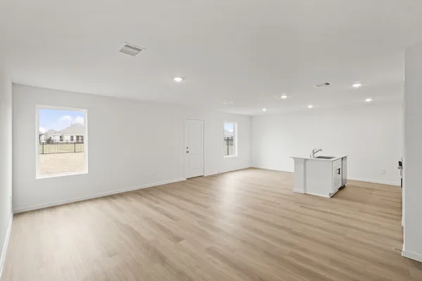 an empty room with wooden floor and window