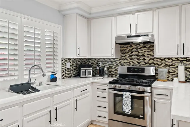 a kitchen with stainless steel appliances a stove sink and cabinets