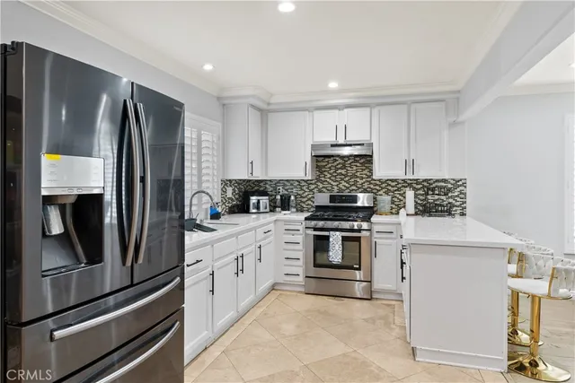 a kitchen with stainless steel appliances granite countertop a refrigerator stove and sink