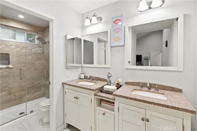 a bathroom with a granite countertop sink a toilet and a mirror