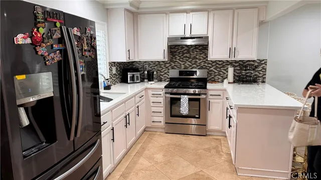 a kitchen with stainless steel appliances granite countertop a stove a refrigerator and a refrigerator
