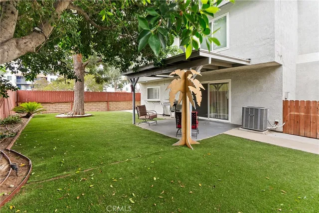 a view of a house with a yard and tree