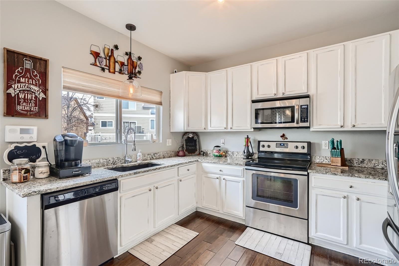 13890 Madison Street Thornton, CO 80602 - Photo 4 of 11 a kitchen with cabinets a sink and appliances