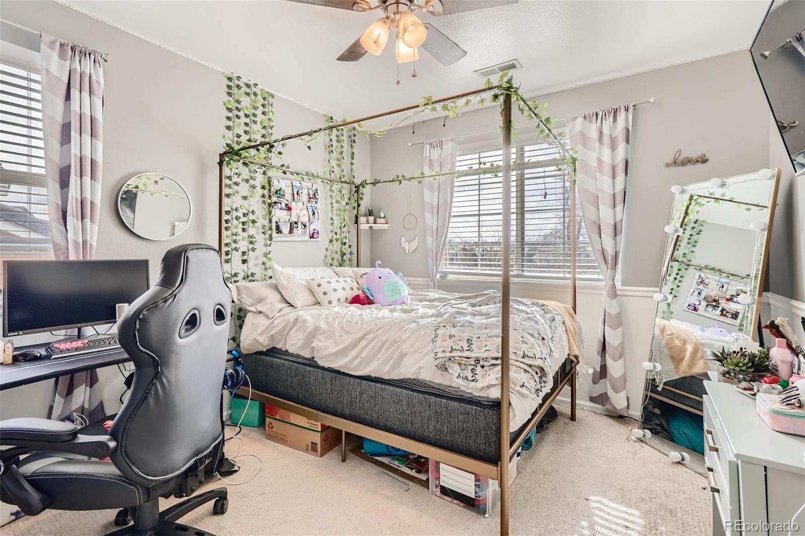 13890 Madison Street Thornton, CO 80602 - Photo 9 of 11 a bedroom with a bed and a chandelier