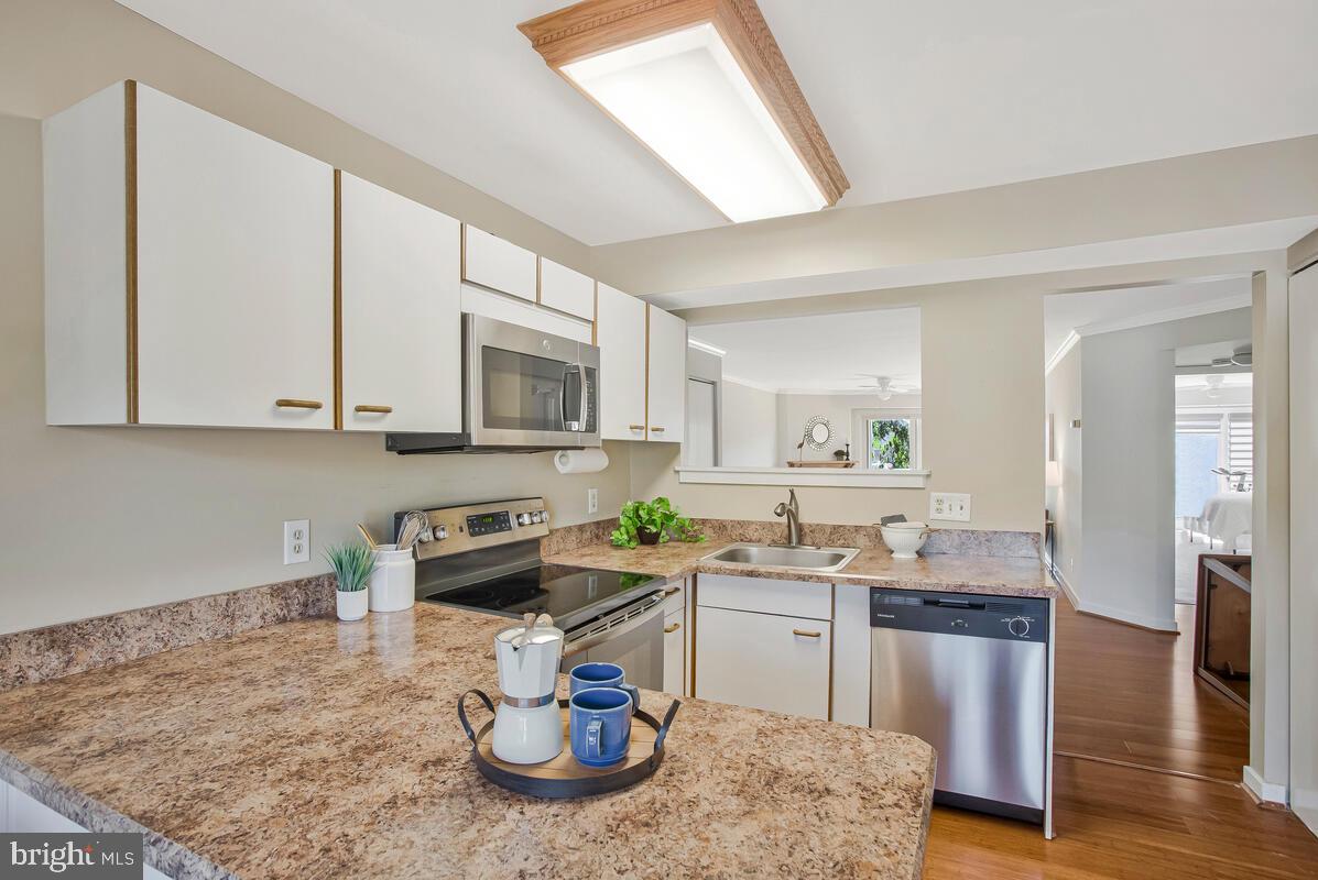 7002 Channel Village Court, Unit 101 Annapolis, MD 21403 - Photo 17 of 48 a kitchen with stainless steel appliances granite countertop a sink stove and cabinets