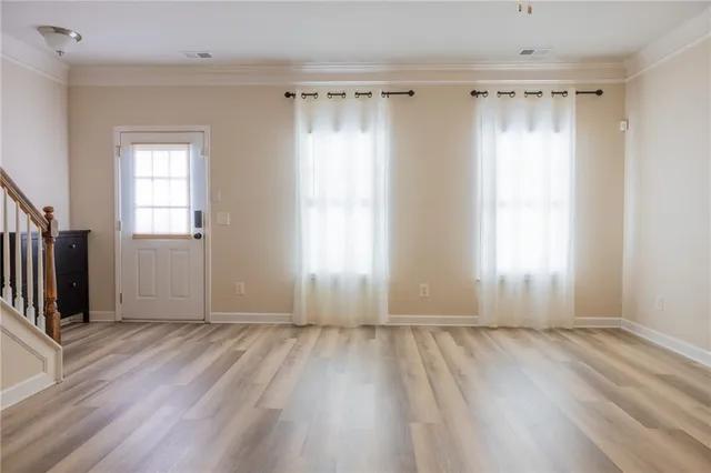 an empty room with wooden floor and a window