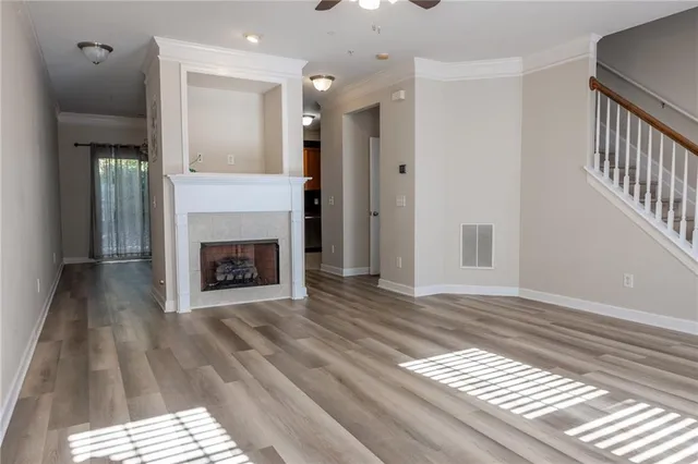 a view of a livingroom with wooden floor and a fireplace