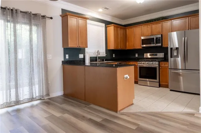 a kitchen with stainless steel appliances granite countertop a refrigerator and a stove top oven
