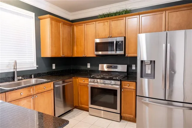 a kitchen with stainless steel appliances granite countertop a refrigerator sink stove microwave and cabinets