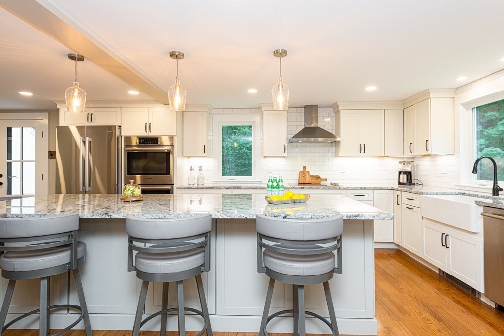 12 Moran Road Lynnfield, MA 01940 - Photo 11 of 42 a kitchen with stainless steel appliances kitchen island granite countertop a sink and cabinets