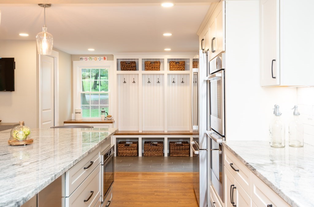 12 Moran Road Lynnfield, MA 01940 - Photo 9 of 42 a large white kitchen with granite countertop a sink and a stove top oven with wooden floor