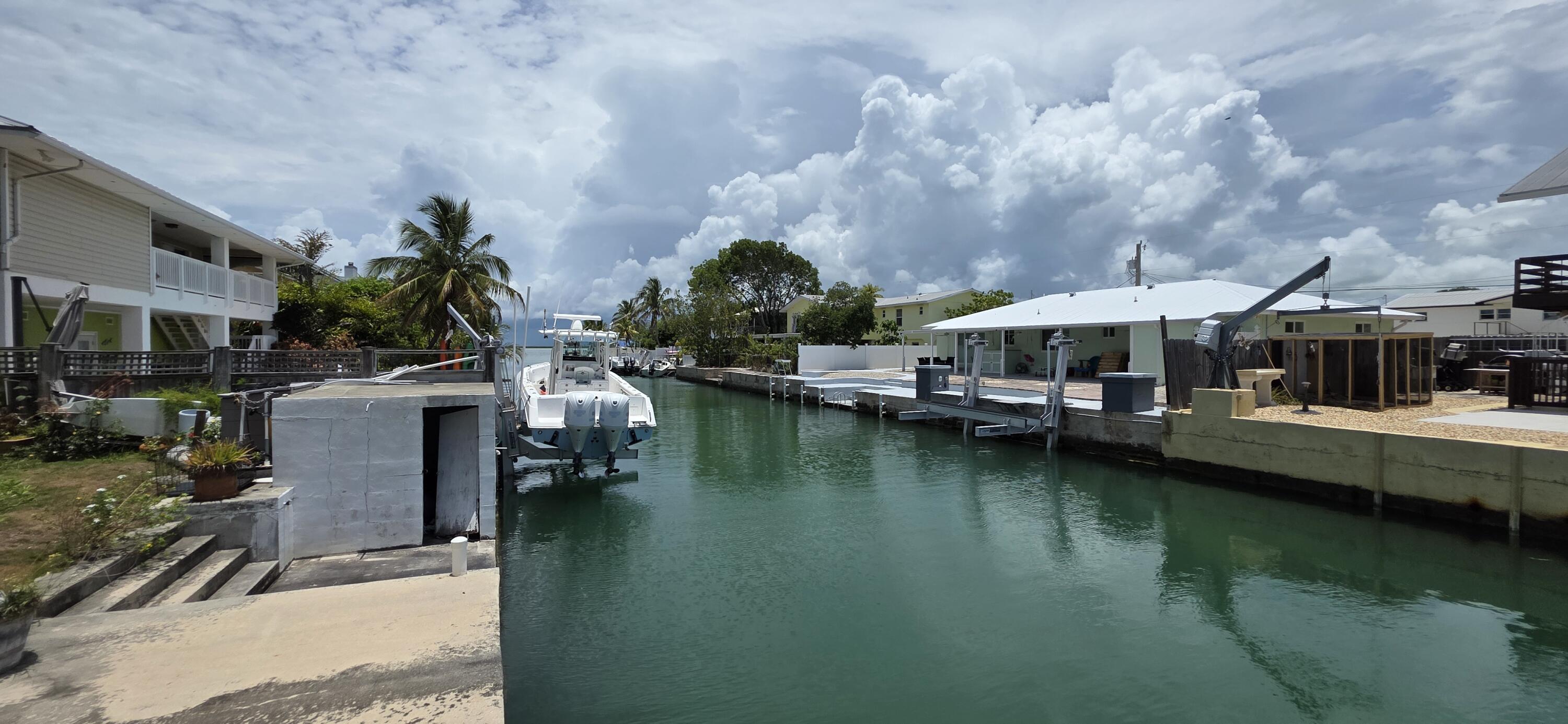 8 Emerald Drive Key West, FL 33040 - Photo 2 of 43 a view of a lake with lawn chairs under an umbrella