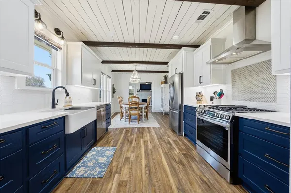 a large kitchen with cabinets wooden floor and stainless steel appliances