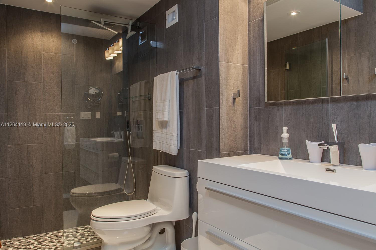 100 Lincoln Road, Unit 943 Miami Beach, FL 33139 - Photo 18 of 56 a bathroom with a sink toilet and shower