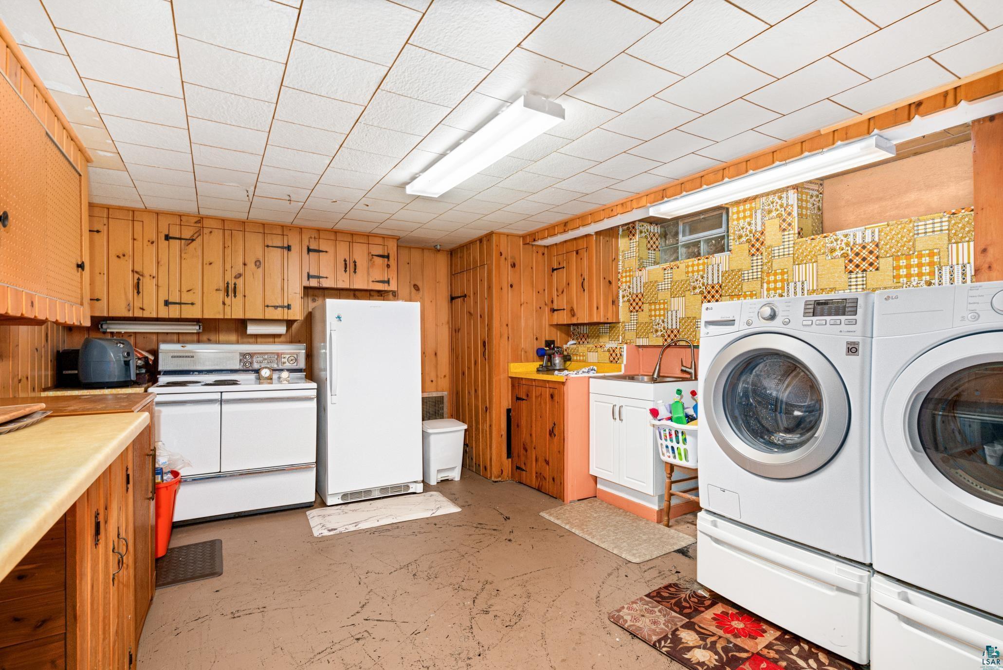 3727 Stebner Road Hermantown, MN 55811 - Photo 28 of 41 Wood paneling and cabinetry throughout, with an integrated laundry area featuring a washer and dryer