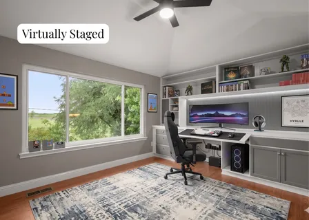 a view of a workspace with furniture and a window