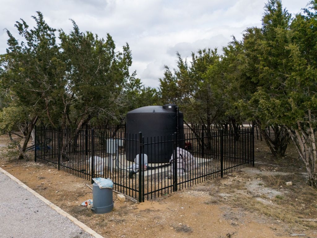 2140 Carpenter Loop Burnet, TX 78611 - Photo 34 of 40 a view of a wooden house with a bench in a backyard