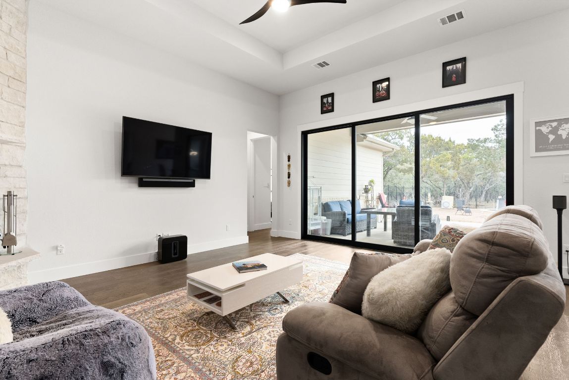 2140 Carpenter Loop Burnet, TX 78611 - Photo 7 of 40 a living room with furniture a flat screen tv and a floor to ceiling window