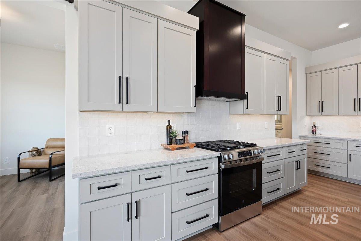 3068 Moonrise Road Twin Falls, ID 83301 - Photo 10 of 43 Kitchen featuring light-toned cabinetry with matte black hardware, white tile backsplash, stainless steel range, and a large single-basin sink with a matte black pull-down faucet