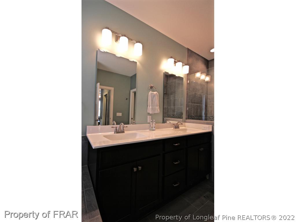 309 Duncan Road Southern Pines, NC 28387 - Photo 24 of 36 a bathroom with a double vanity sink and a mirror