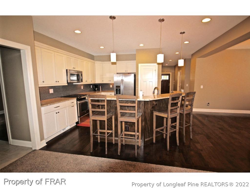 309 Duncan Road Southern Pines, NC 28387 - Photo 8 of 36 a kitchen with stainless steel appliances a dining table chairs and granite counter tops