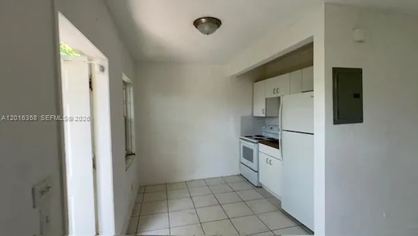 a kitchen with granite countertop a refrigerator and a stove top oven