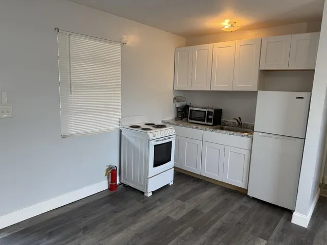a kitchen with white cabinets and white appliances