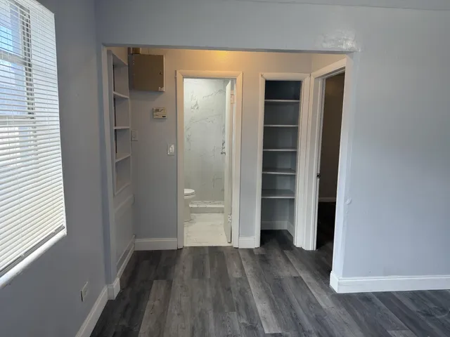 a view of a hallway with wooden floor and closet