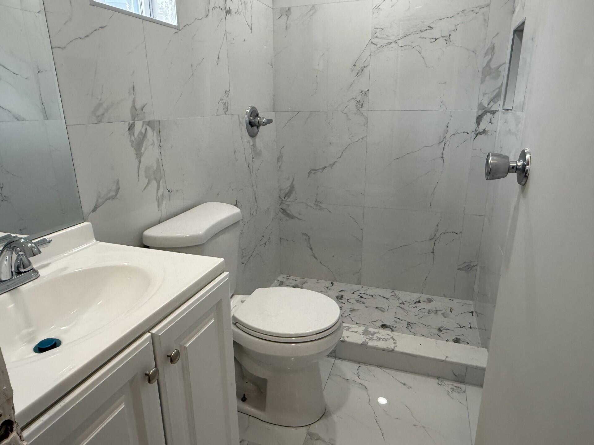 131 East 27th Street, Unit 1 Riviera Beach, FL 33404 - Photo 7 of 10 a bathroom with a sink a toilet and a mirror