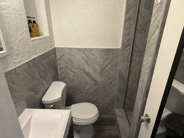 a white toilet sitting next to a bathroom sink and vanity